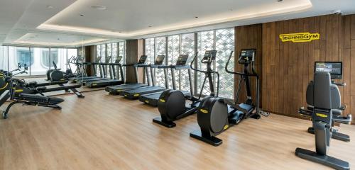 a gym with treadmills and ellipticals in a building at The Salil Hotel Riverside Bangkok in Bangkok