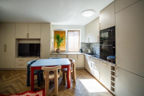 a kitchen with a table and some chairs in it at Apartament Mikołowska z balkonem in Gliwice