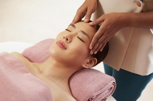 a woman getting her face washed by a beautician at The Salil Hotel Riverside Bangkok in Bangkok