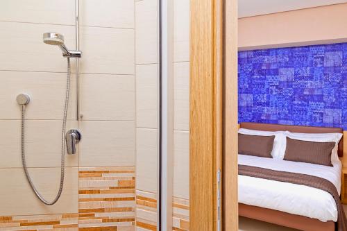 a bathroom with a shower and a bed in a room at Airone Hotel in Naples