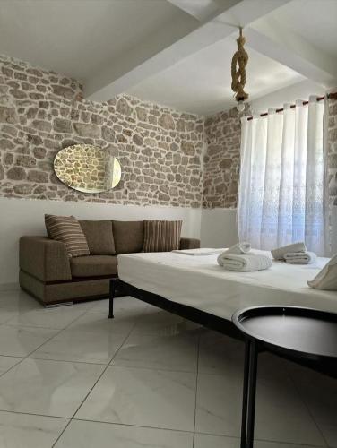 a bedroom with a large bed and a couch at Polyxeni Apartments & Rooms in Qeparo