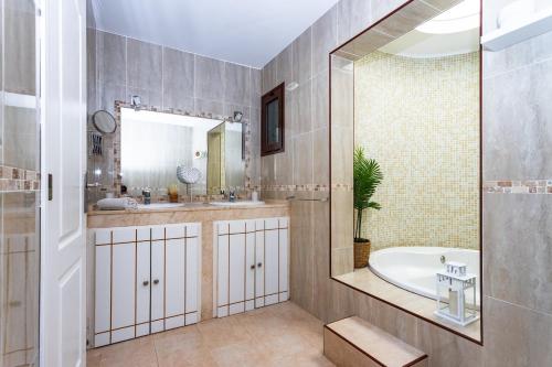 a bathroom with a tub and a sink and a mirror at Villa ConchaMar Oceanbeach in Playa Honda