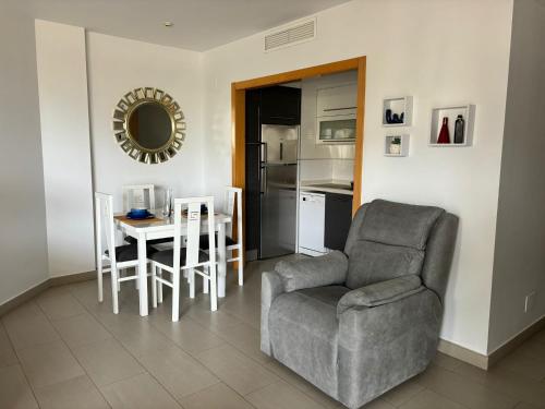 ein Wohnzimmer mit einem Stuhl, einem Tisch und einem Spiegel in der Unterkunft Beach Albir in Albir