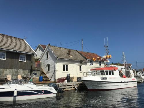 three boats are docked at a dock in the water at Brightside Apartment in Kristiansand