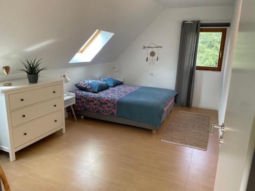 una camera da letto con un letto, un comò e una finestra di La Mouette Rose - a zen guest-house in Lauterbourg a Lauterbourg