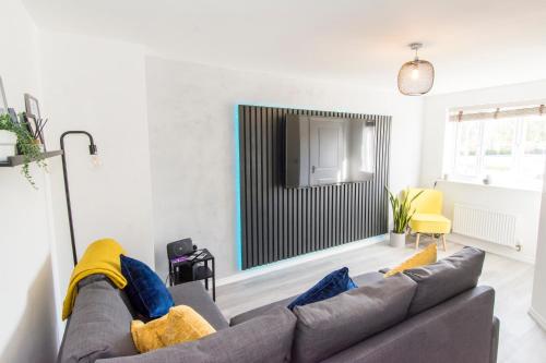 a living room with a couch and a television at Host & Stay - Polwell Road in Kibworth Harcourt
