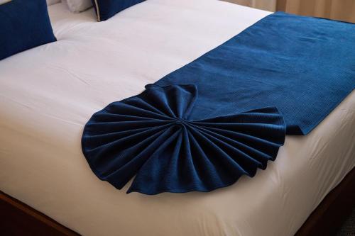 a blue comforter on top of a bed at Fourteen Hotel Ain Sebaa in Casablanca