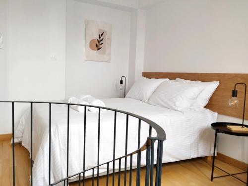 a bedroom with a white bed with a wooden headboard at Marelia Urban in Thessaloniki