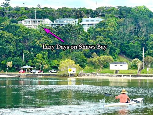 a man in a kayak on a river with the words days on shaws at Two Apartments SALT & SAND at Lazy Days on Shaws Bay - 150m to Shaws Bay in East Ballina