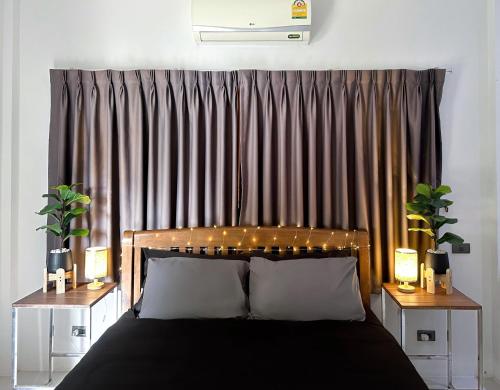 a bedroom with a bed and a curtain with lights at Bangrak Cozy Stay in Koh Samui 