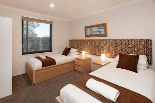 a bedroom with two beds and a window at Aalen Lakeview Suite in Jindabyne