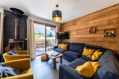 un salon avec un canapé bleu et une cheminée dans l'établissement Chalet Rivendell, Morzine sleeps 10 with garage, à Morzine