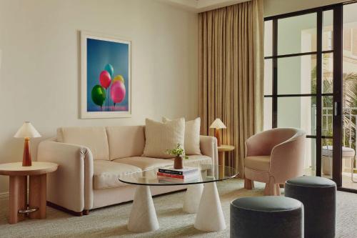 a living room with a couch and a table and chairs at The Maybourne Beverly Hills, Maybourne in Los Angeles