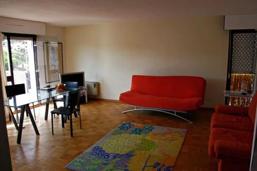 - un salon avec un canapé rouge et un bureau dans l'établissement Soleil Maxime, à Sainte-Maxime