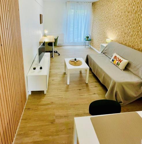 a living room with a bed and a table at Sphinx Résidences - Tempologis Mémorial in Caen