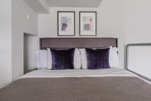 a bedroom with a bed with purple pillows at Blueground Tacoma gym elevator lounge wd SEA-773 in Seattle