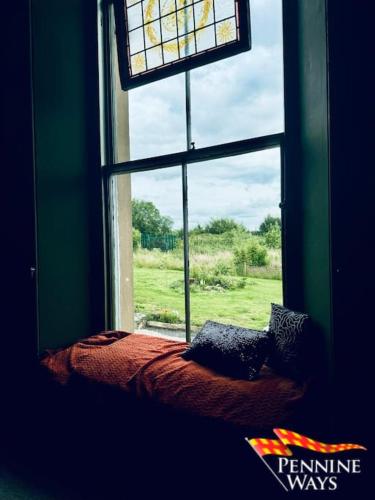 a window in a room with a bed in front of it at Greystonedale Mansion, Haltwhistle in Haltwhistle