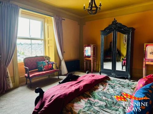 a bedroom with a bed and a mirror and a chair at Greystonedale Mansion, Haltwhistle in Haltwhistle