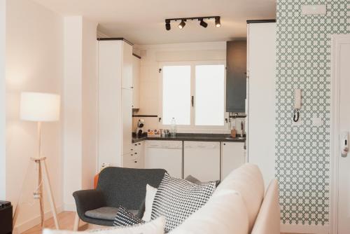 a living room with a couch and a kitchen at Mirando al sella in Arriondas