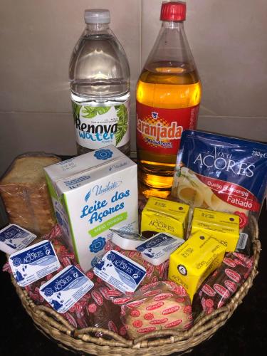 a basket filled with food and two bottles of soda at Vivenda Flor in Ponta Delgada
