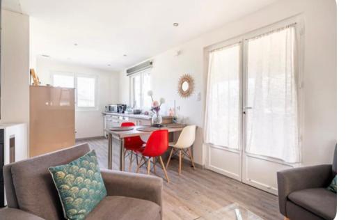 un salon avec une table et des chaises et une cuisine dans l'établissement Le chalet de la prairie, à Beaucroissant