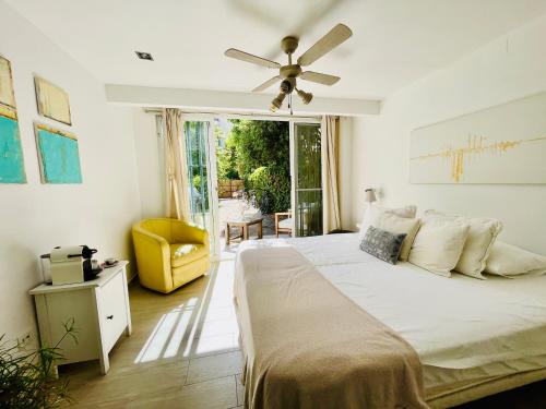 a bedroom with a bed and a ceiling fan at SuperHosts Suites Estepona in Estepona