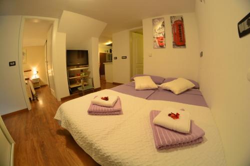 1 dormitorio con 1 cama grande y toallas. en Apartment Arpa, en Liubliana