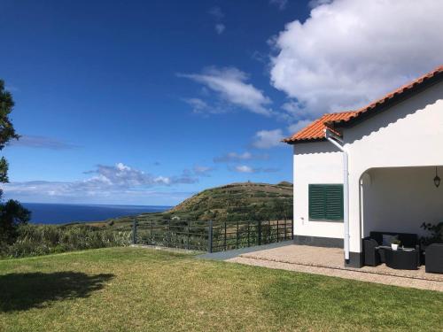 a white house with a view of the ocean at Vivenda Flor in Ponta Delgada