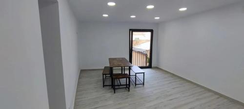 Una mesa y sillas en una habitación blanca con una ventana. en Welcoming Apartment in Igualada - 65.2 m² - 8 people, en Igualada