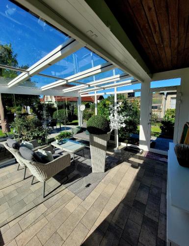 a patio with couches and a table and chairs at Ferienhaus Grüner Bungalow Kontaktloser CheckIn in Stendell