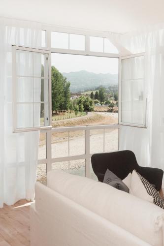 a living room with a white couch and a large window at Mirando al sella in Arriondas