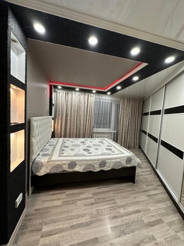 een slaapkamer met een bed in een kamer bij 2 ком люкс в центре города in Karagandy