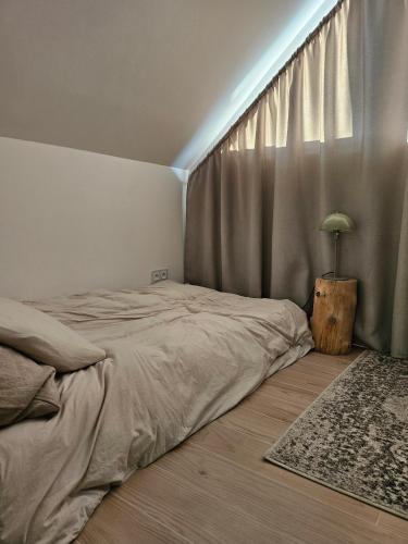 a bedroom with a bed and a window with a rug at Domek w Lesie z Kominkiem i Ogrodem Niedalino in Niedalino