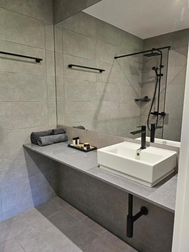 a bathroom with a white sink and a shower at Domek w Lesie z Kominkiem i Ogrodem Niedalino in Niedalino