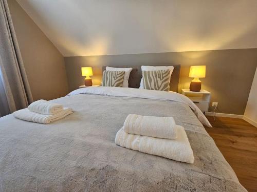 a bedroom with a large bed with towels on it at La Maison des Saveurs in Trouville-sur-Mer
