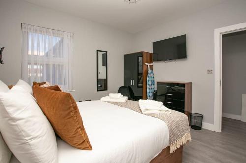 a bedroom with a white bed and a flat screen tv at Stylish and Homey 2 bedroom in Abbey Wood in Abbey Wood