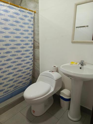 a bathroom with a toilet and a sink at Palmerai BUCAY in Cumanda