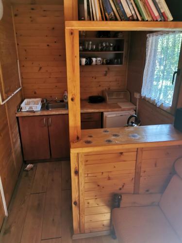 a kitchen in a log cabin with a desk at Domki drewniane alpejskie in Świętne