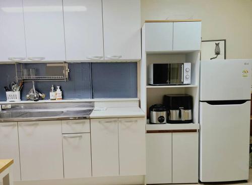 a kitchen with white cabinets and a white refrigerator at Maru house Tranquil and Airy Space for Long or Short Stays in Nowon 2 qeen bed, near market, air-conditioner, Samsung TV in Seoul