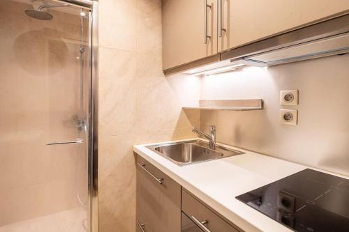 Il comprend une petite cuisine avec un évier et une douche. dans l'établissement Studio Hotel - 2 pers, à Paris