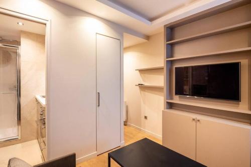 un salon avec une télévision et une table dans l'établissement Studio Hotel - 2 pers, à Paris