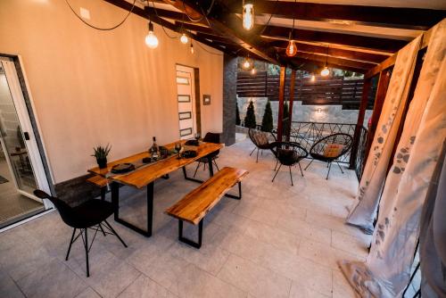 a patio with wooden tables and chairs in a room at Fruška Kuća in Vrdnik