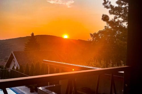 a sunset over a house with the sun on a hill at Fruška Kuća in Vrdnik