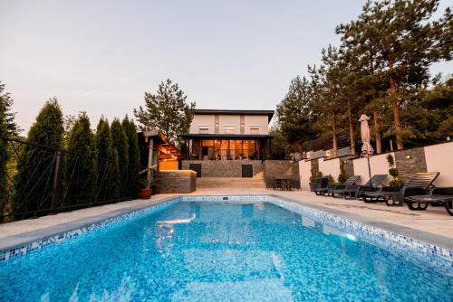 a swimming pool in front of a house at Fruška Kuća in Vrdnik