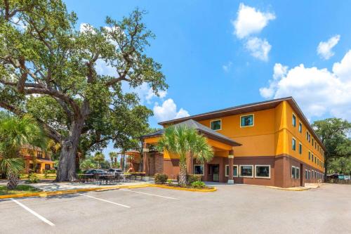 a large yellow building with a parking lot at Days Inn by Wyndham Biloxi Beach in Biloxi