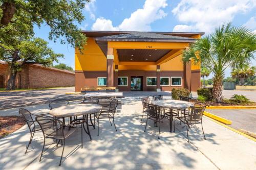 a group of tables and chairs in front of a building at Days Inn by Wyndham Biloxi Beach in Biloxi