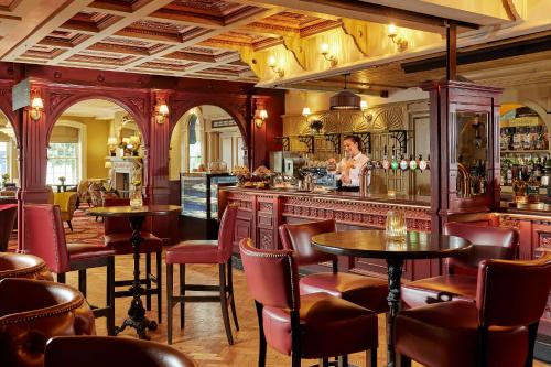 a woman standing at a bar in a restaurant at Bridge House Hotel, Leisure Club & Spa in Tullamore