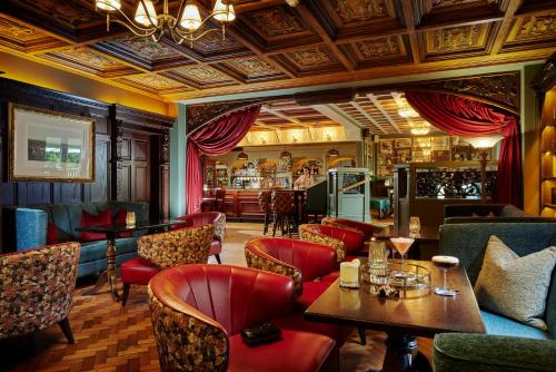 a restaurant with red chairs and tables and a bar at Bridge House Hotel, Leisure Club & Spa in Tullamore