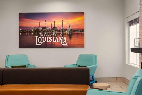a waiting room with chairs and a painting on the wall at La Quinta by Wyndham Gonzales LA in Gonzales