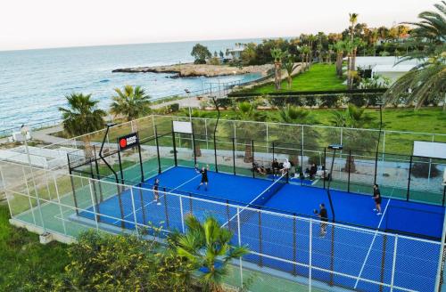 an overhead view of a tennis court next to the ocean at Lucile - Coralli Beachfront Apartment in Paralimni
